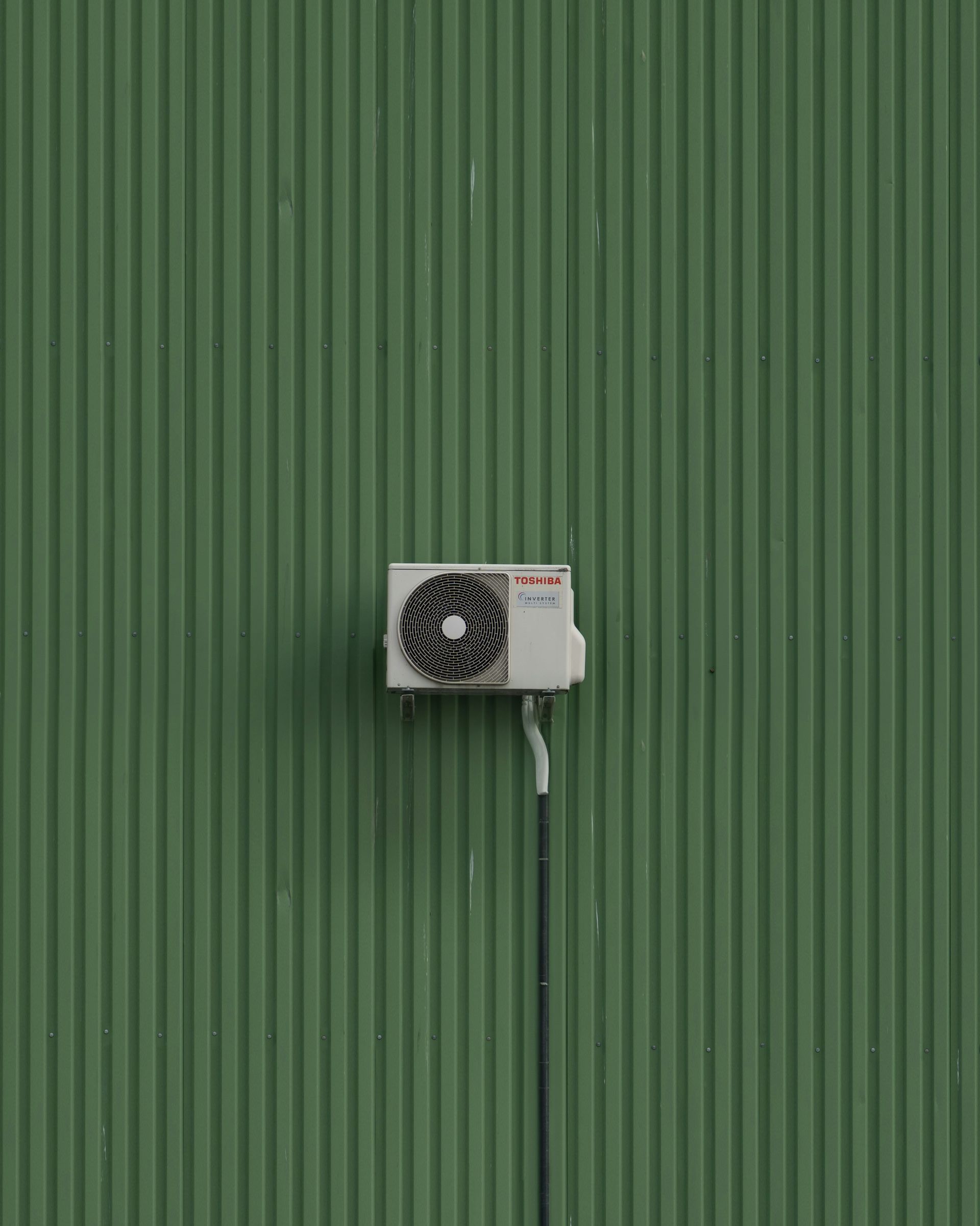 A green wall with a white and black object on it